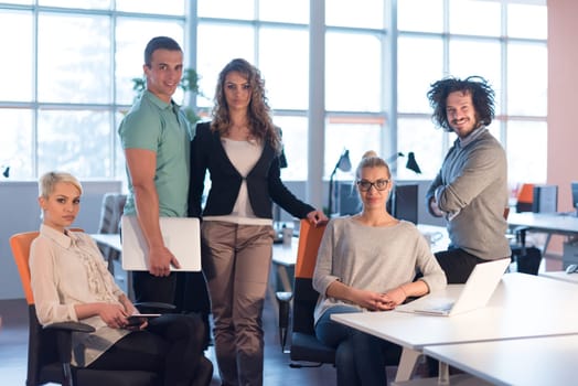 Portrait of young business people discussing business plan  in the office