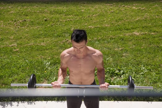 young handsome man doing morning exercises in front of his luxury home villa