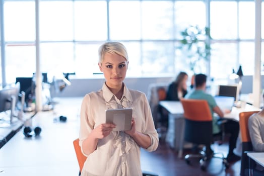 young female entrepreneur working on digital tablet in night office