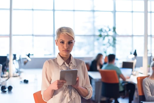 young female entrepreneur working on digital tablet in night office