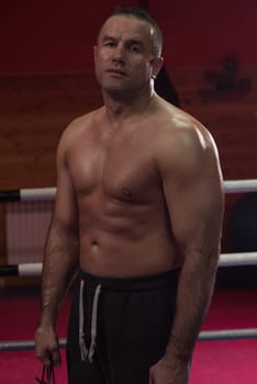 portrait of muscular professional kickboxer who standing in the ring while training for the fight