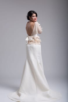 Rear view of a beautiful young bride in a wedding dress isolated on a white background