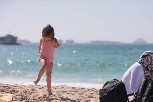 happy little girl at the seaside in the summer.Adorable little girl at beach during summer vacation. Happy baby by the sea or ocean