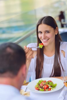 happy young couple having lanch at beautiful restaurant on by the sea on  beach