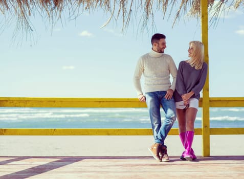 Happy couple enyojing time together on beach during autumn day colored filter