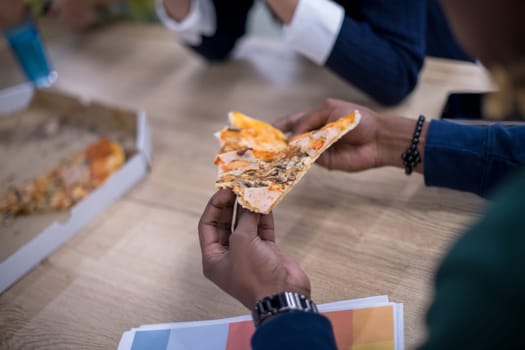 Friendly diverse multiethnic business team eating sharing pizza together in startup office, multiracial coworkers staff group enjoying break talking laughing on lunch time at meeting