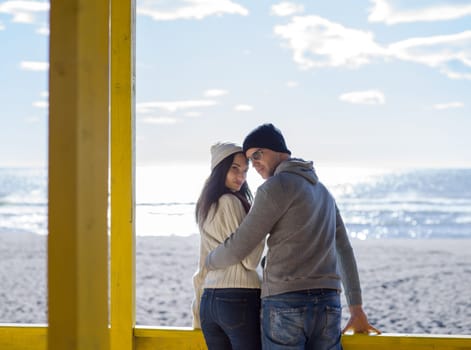 Happy couple enyojing time together on beach during autumn day