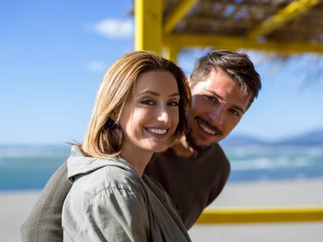 Happy couple enyojing time together on beach during autumn day