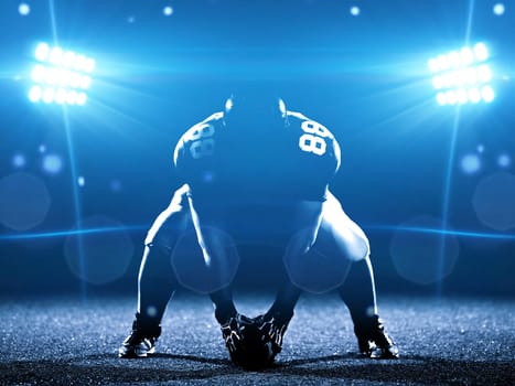 American football player starting football game on american football field at night