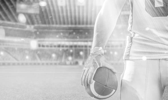 Closeup Portrait of a strong muscular American Football Player on big modern stadium field with lights and flares