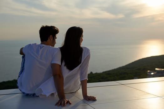 happy young romantic couple have fun relax smile at modern home outdoor terace balcony