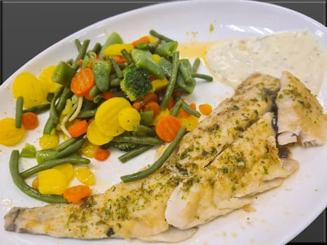 Fried fish on green asparagus with salad