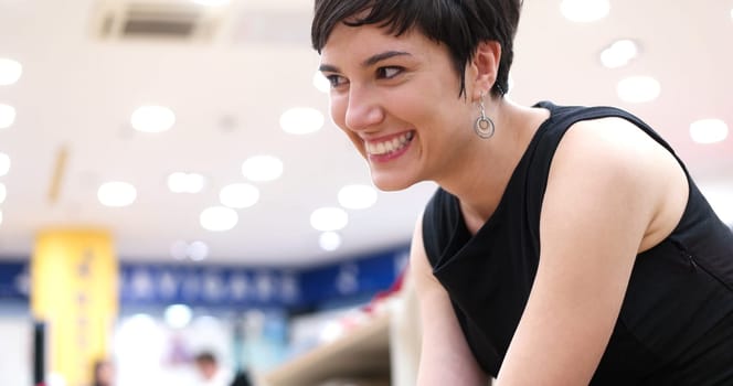 Woman Chooses  Shoes At Fashionable Shop