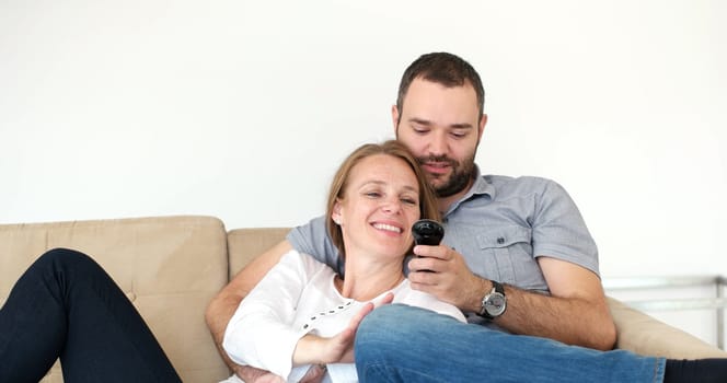Senior couple sitting in couch and watching tv