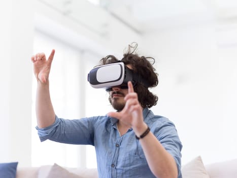 happy man getting experience using VR-headset glasses of virtual reality at home