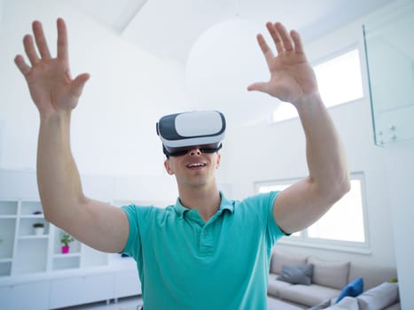 happy man getting experience using VR-headset glasses of virtual reality at home