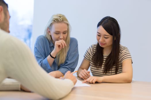 Group of a young business people discussing business plan at modern startup office building