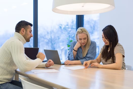 Group of a young business people discussing business plan at modern startup office building