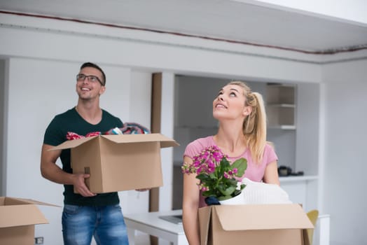 Happy young couple unpacking or packing boxes and moving into a new home