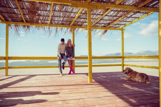 Happy couple enyojing time together on beach during autumn day