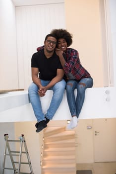Happy young African American couple having break during moving to new house