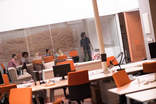 Multiethnic startup business team on meeting in modern bright office interior brainstorming, working on laptop and tablet computer