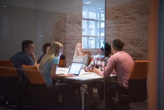 Multiethnic startup business team on meeting in modern bright office interior brainstorming, working on laptop and tablet computer