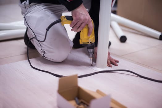 repairman working with drilling machine and assambling  furniture