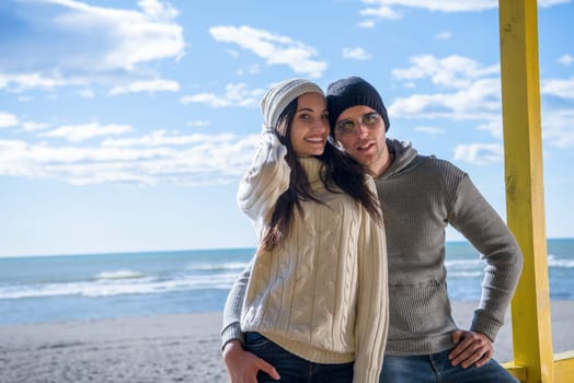 Happy couple enyojing time together on beach during autumn day
