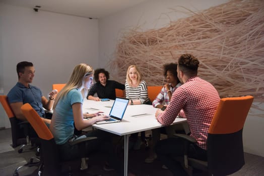 Multiethnic startup business team on meeting in modern bright office interior brainstorming, working on laptop and tablet computer