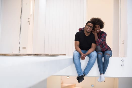 Happy young African American couple having break during moving to new house
