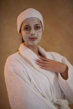 Spa Woman applying Facial Mask  Beauty Treatments  Close up portrait of beautiful girl with a towel on her head applying facial mask