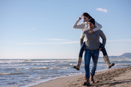 Men Giving Piggy Back Rides his girlfriend At Sunset By The Sea, autumn time