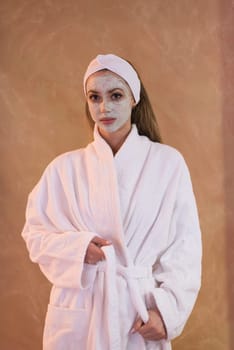Spa Woman applying Facial Mask  Beauty Treatments  Close up portrait of beautiful girl with a towel on her head applying facial mask