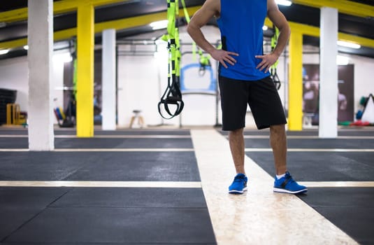 Young strong man doing pushups  at cross fitness gym
