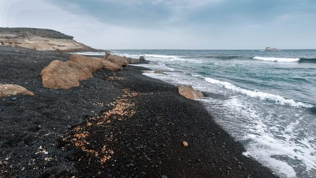 Seascape of deserted shore and ocean waves at cloudy windy day.
