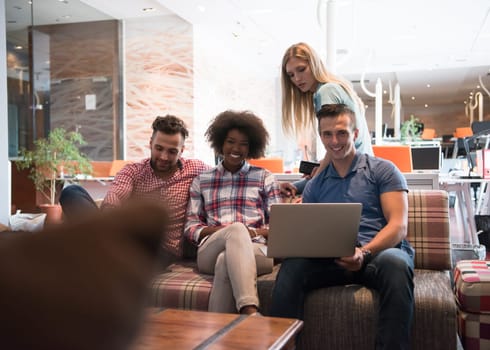 Multiethnic startup business team on meeting in modern bright office interior brainstorming, working on laptop and tablet computer