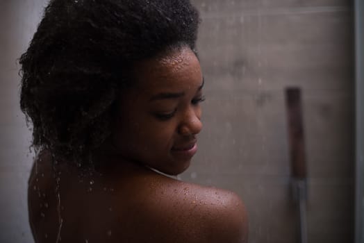 Woman in the shower,beautiful black young female showering under refreshing water, healthy lifestyle, enjoying time in luxury spa resort