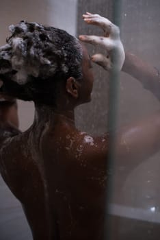 Woman in the shower,beautiful black young female showering under refreshing water, healthy lifestyle, enjoying time in luxury spa resort