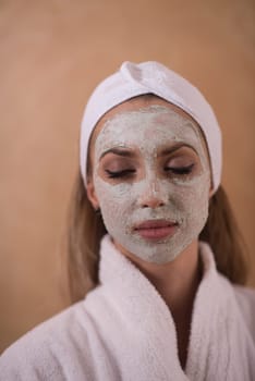 Spa Woman applying Facial Mask  Beauty Treatments  Close up portrait of beautiful girl with a towel on her head applying facial mask