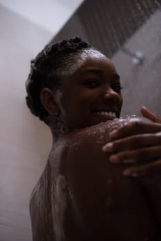 Woman in the shower,beautiful black young female showering under refreshing water, healthy lifestyle, enjoying time in luxury spa resort