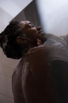 Woman in the shower,beautiful black young female showering under refreshing water, healthy lifestyle, enjoying time in luxury spa resort