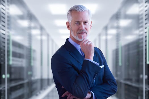Portrait of senior businessman in big rack server room
