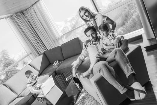 happy couple spending time with kids using tablet computer on an armchair  at home