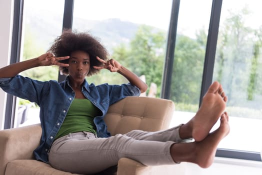 Young african american woman at home in the chair relaxing in her luxury home