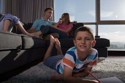 Happy Young Family Playing Together at home on the floor using a tablet and a children's drawing set