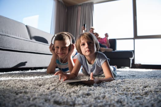 Happy Young Family Playing Together at home.kids using tablet on the floor