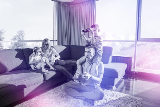 Happy family. Father, mother and children playing a video game Father and son playing video games together on the floor