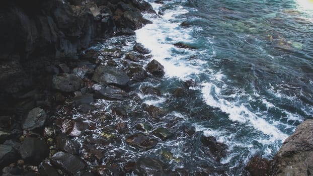 Toned image of small ocean lagoon between sharp cliffs and rocks.