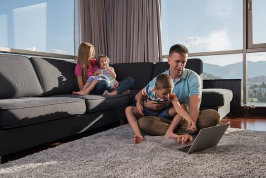 Happy family. Father, mother and children playing a video game Father and son playing video games together on the floor